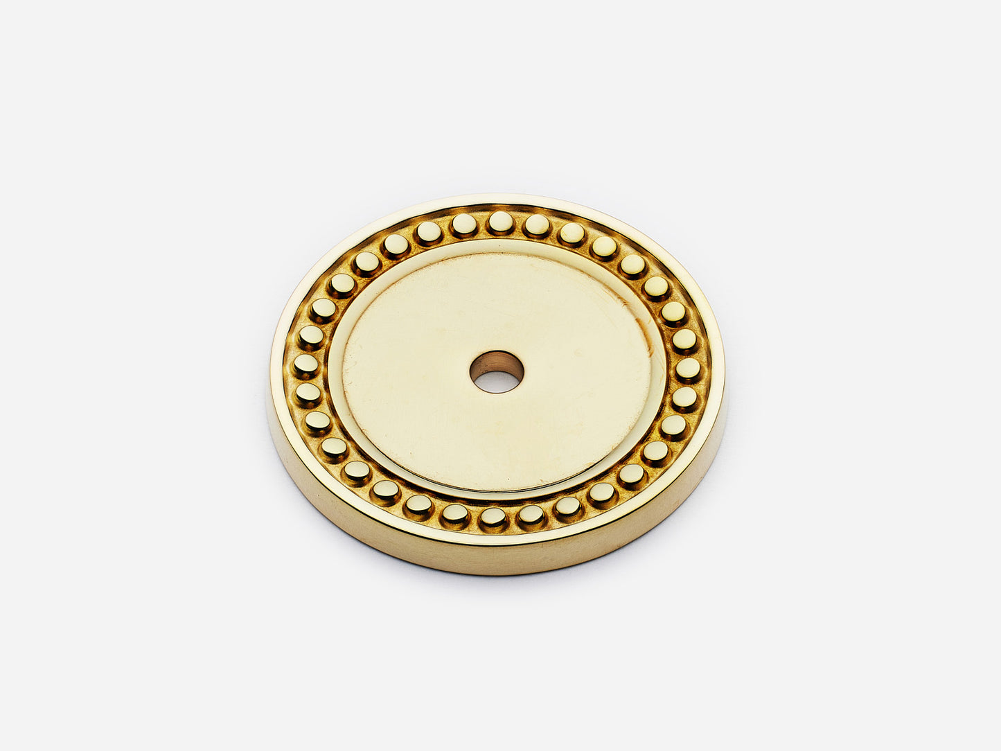 Solid brass Beaded Round backplate, in an unlacquered polished brass finish for knobs on cabinets.