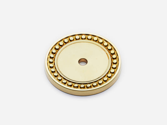 Solid brass Beaded Round backplate, in an unlacquered polished brass finish for knobs on cabinets.