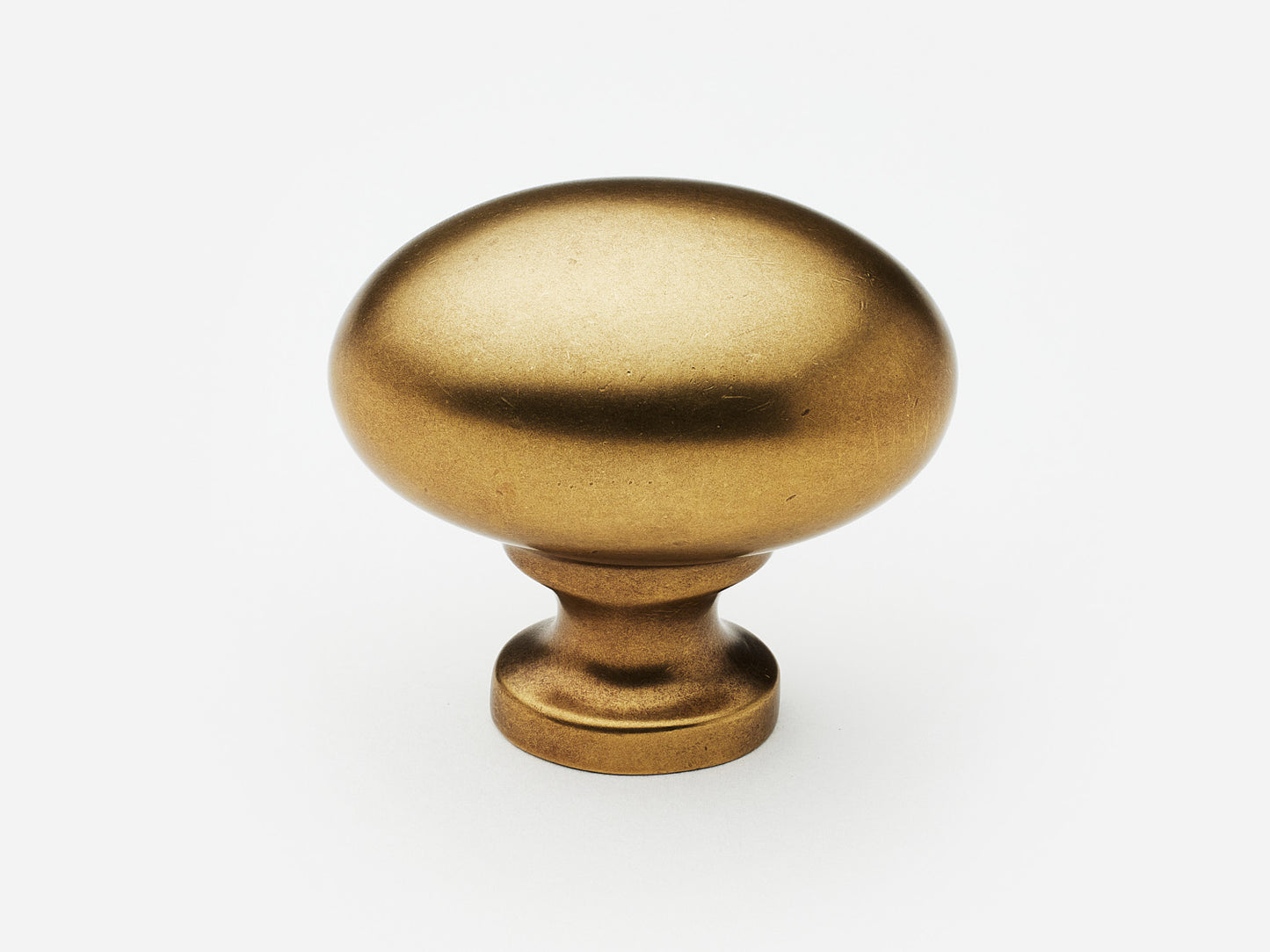Solid brass Oval Knob, standard size, in an aged brass finish for cabinets.