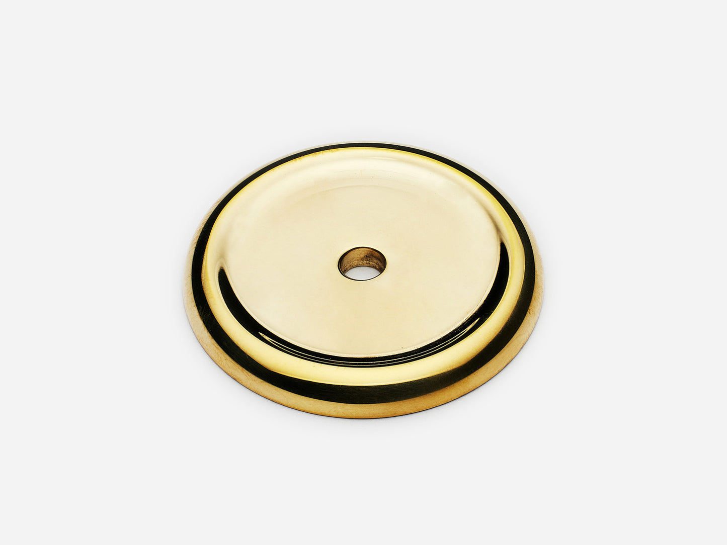 Solid brass Raised Round backplate, in an unlacquered polished brass finish for knobs on cabinets.