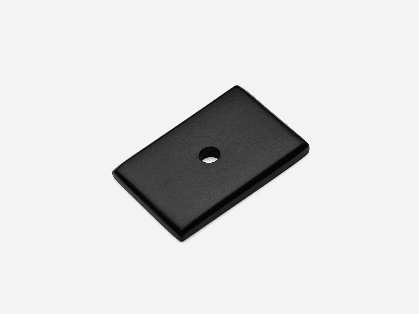 Solid brass rectangular backplate, 1x1.5 inches, matte black finish for knobs and pulls on cabinets.