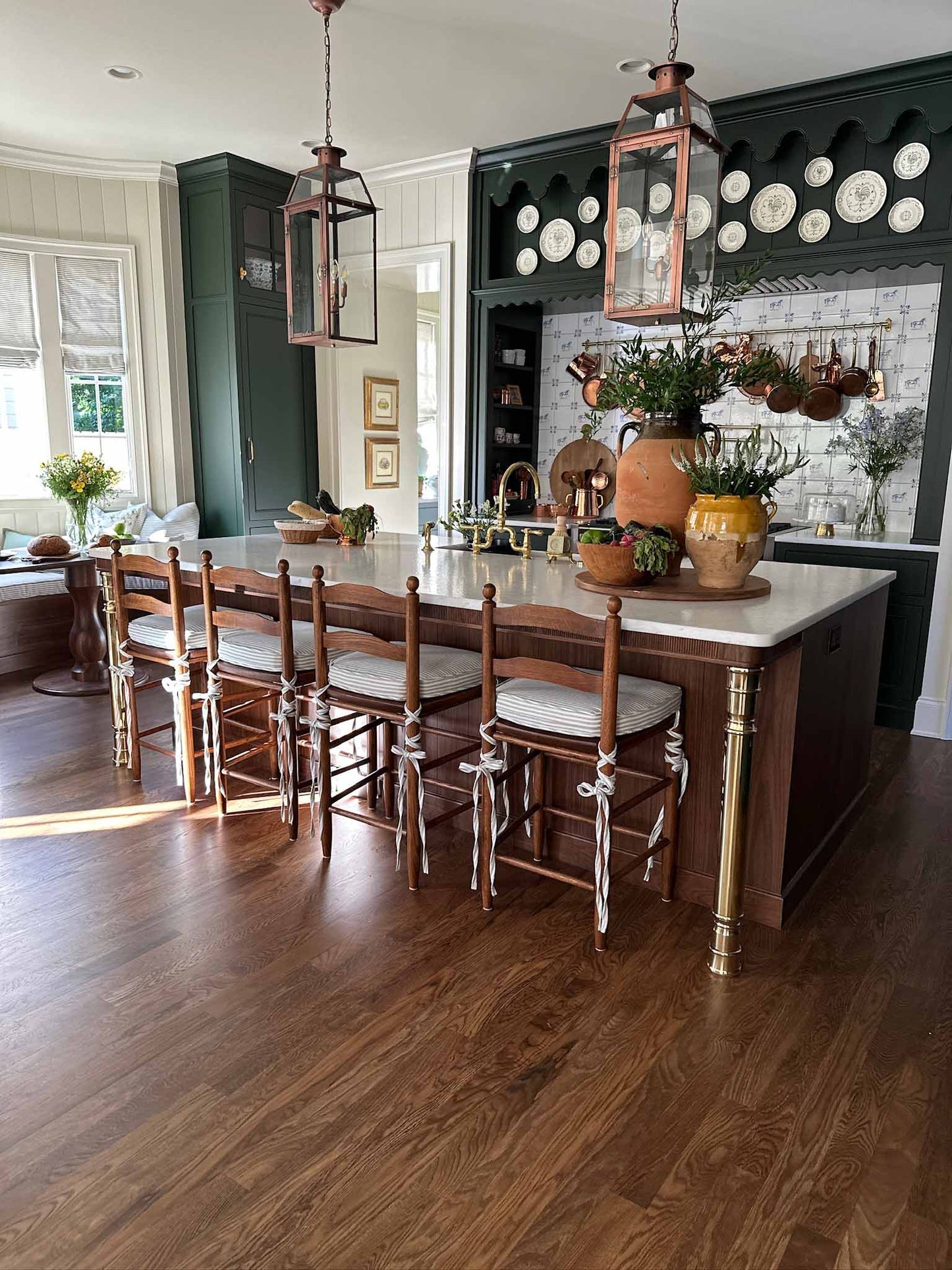 A solid brass kitchen island leg, with an unlacquered polished brass finish, installed on a wood kitchen island in a traditional styled kitchen.
