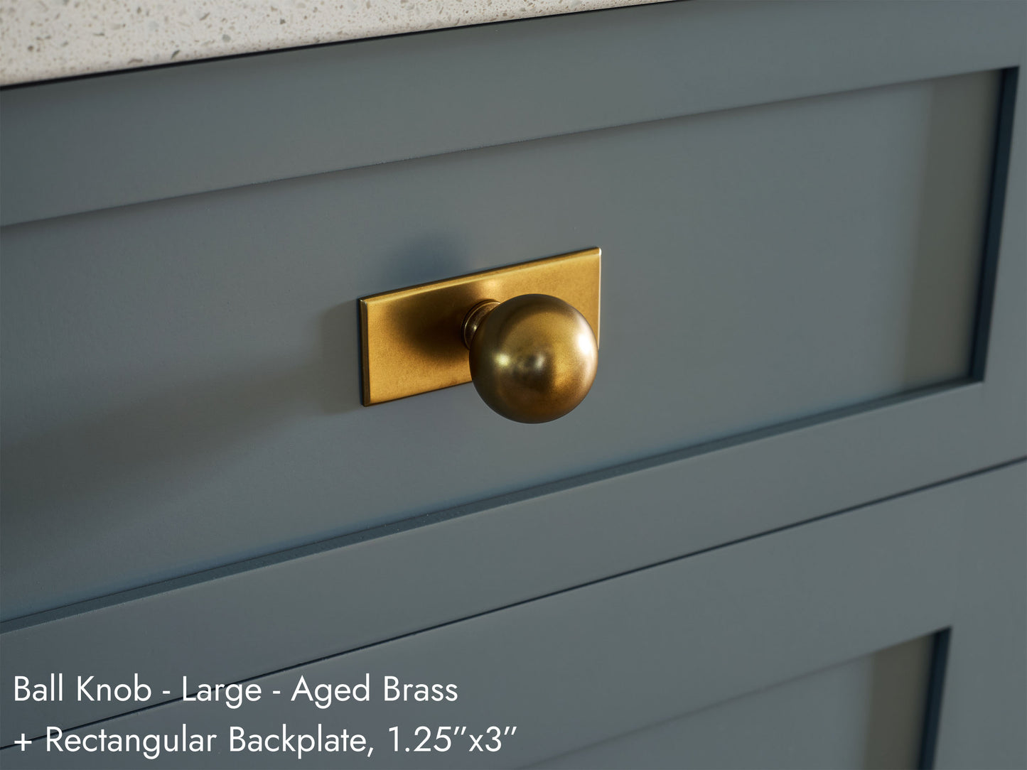 Solid brass Ball Knob, in aged brass finish, on kitchen cabinets with Rectangular Backplate.