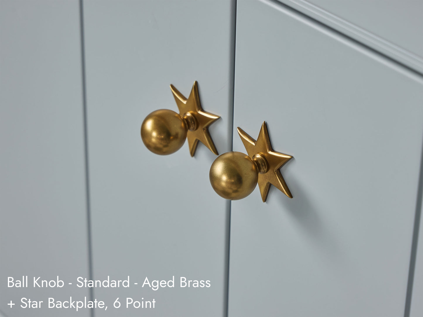 Solid brass Ball Knob, in aged brass, with 6 Point Star Backplate, on kitchen cabinets.