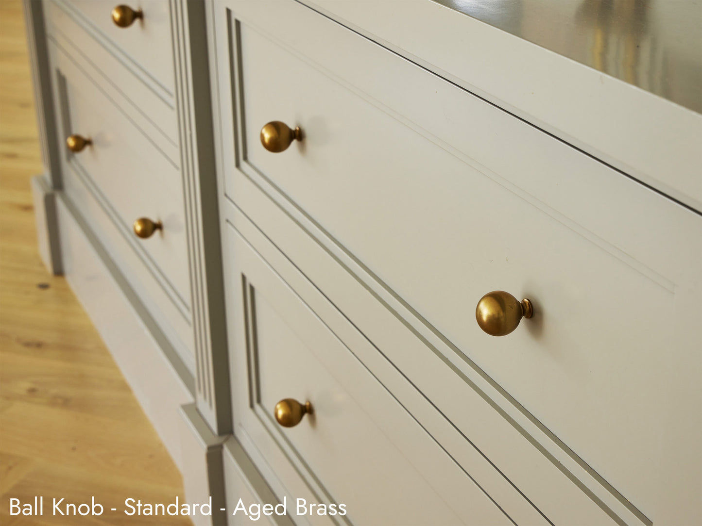 Solid brass Ball Knobs in an Aged Brass finish on kitchen cabinets.