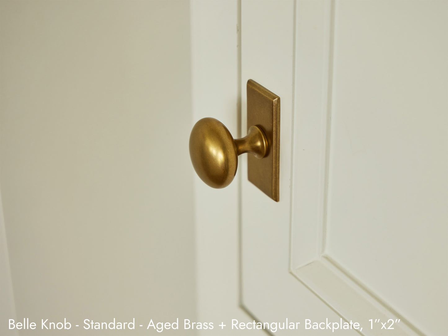 Solid brass Belle Knob in aged brass on kitchen cabinets with a Rectangular Backplate.