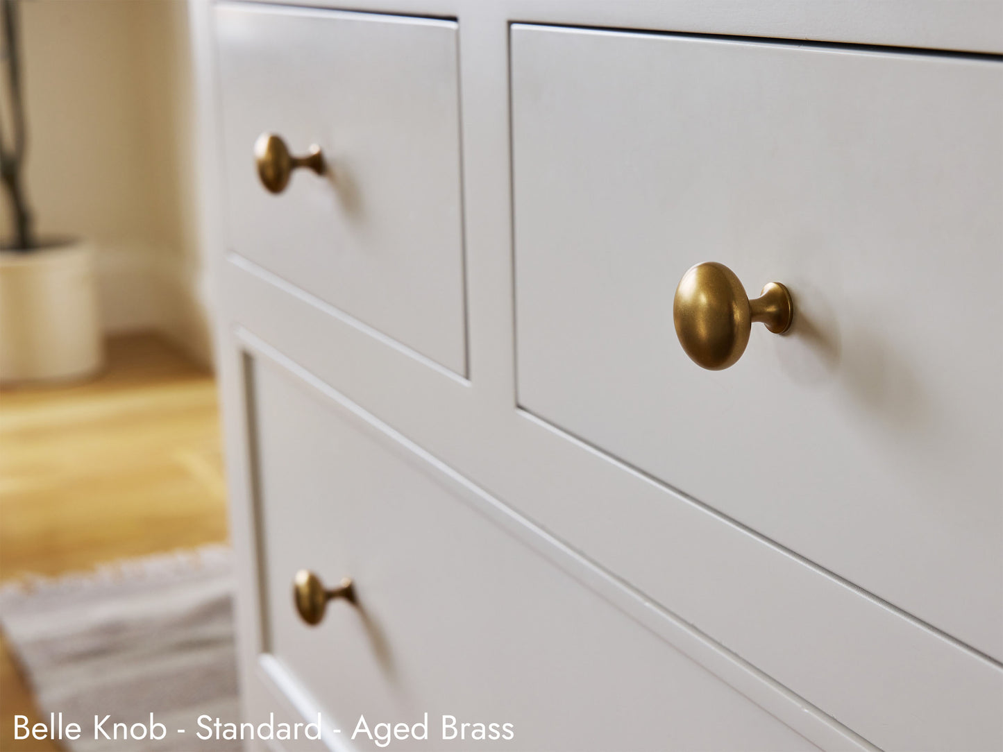 Solid brass Belle Knob in aged brass on kitchen cabinets.