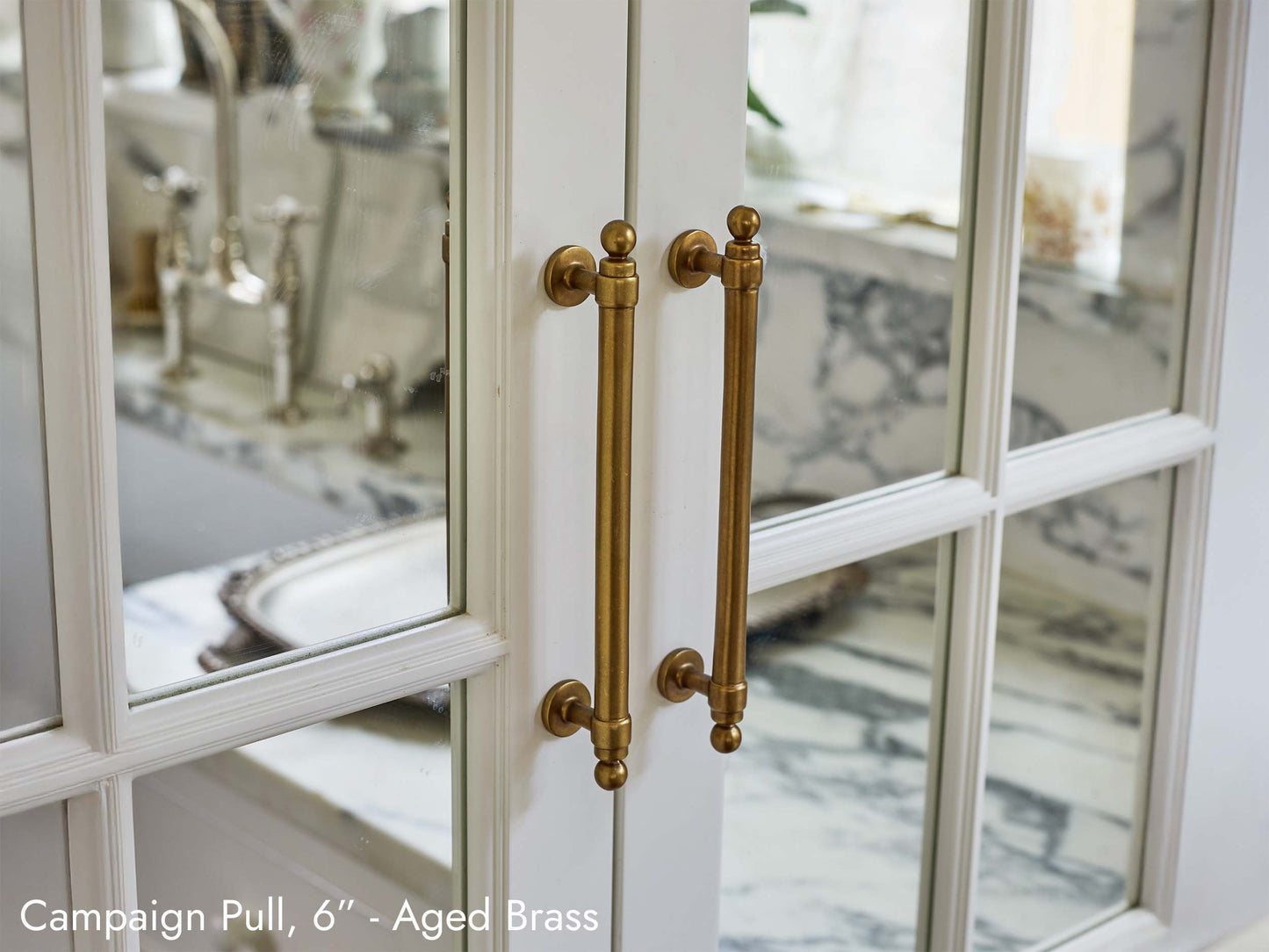 Solid brass Campaign Pulls, in aged brass finish, on kitchen cabinets.