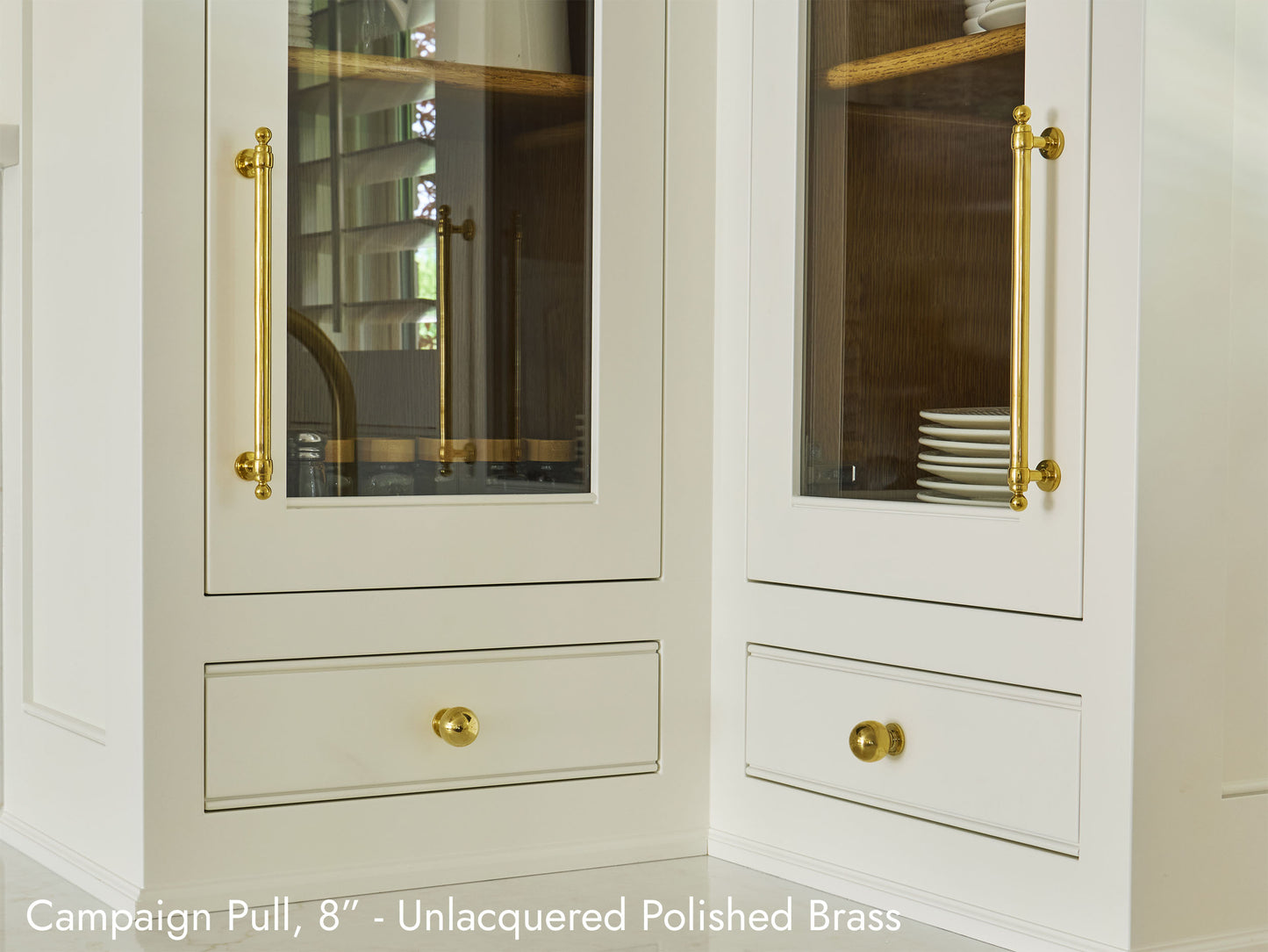 Solid brass Campaign Pull, in unlacquered polished brass finish, on kitchen cabinets.