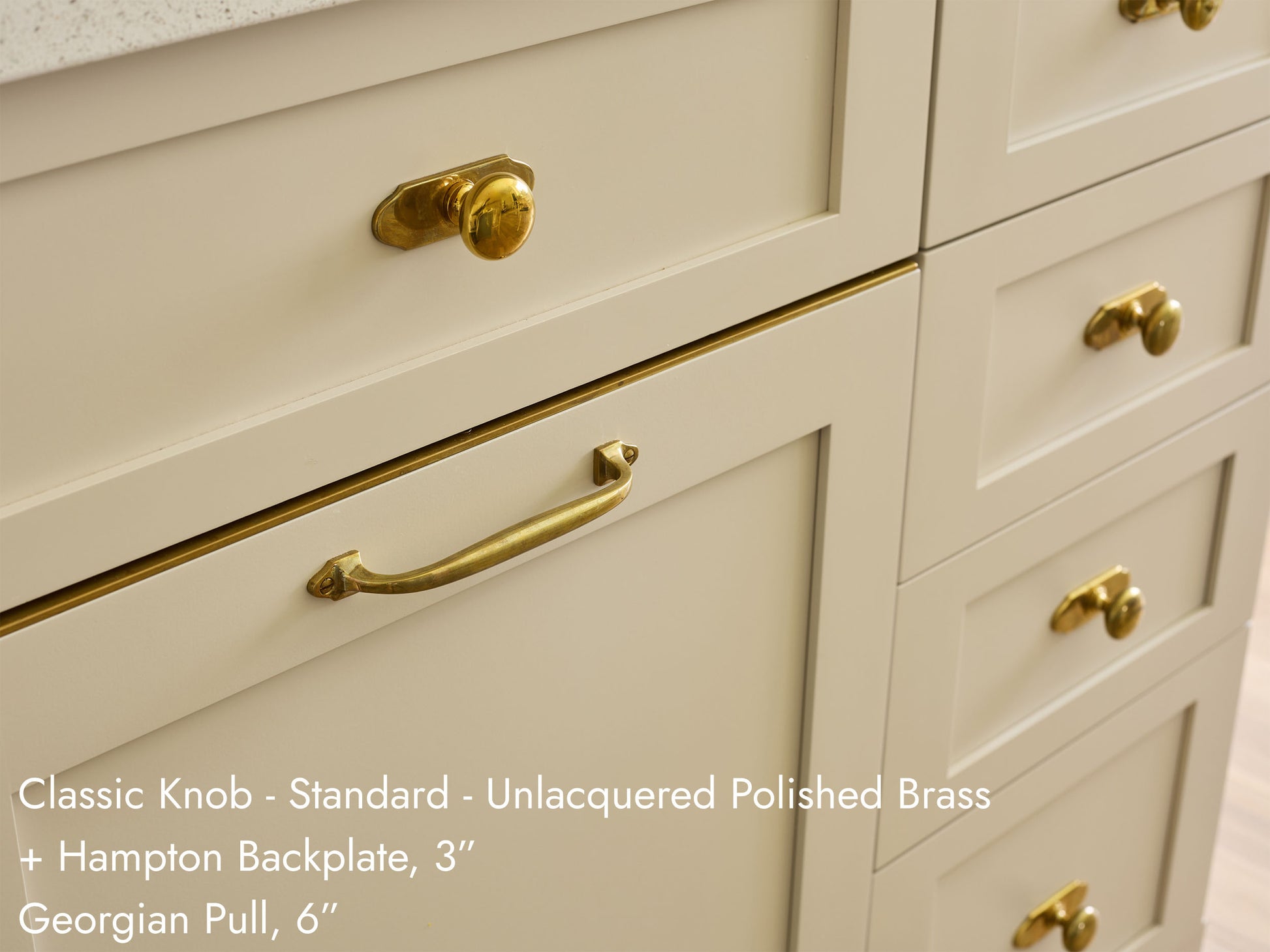 Solid brass Classic Knob, in unlacquered polished brass finish, on kitchen cabinets.
