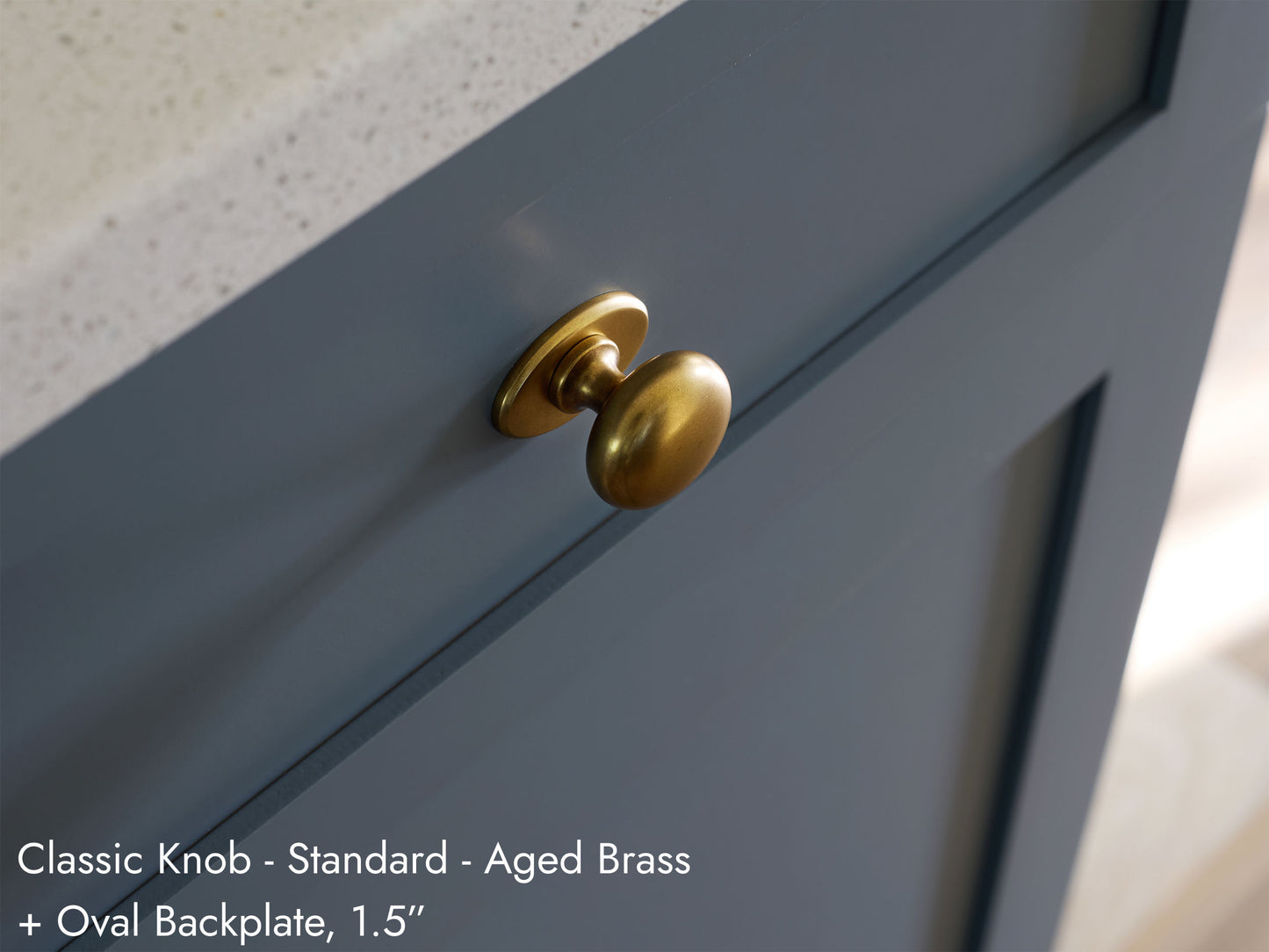 Solid brass Classic Knob, in aged brass finish, on kitchen cabinets with Oval Backplate.