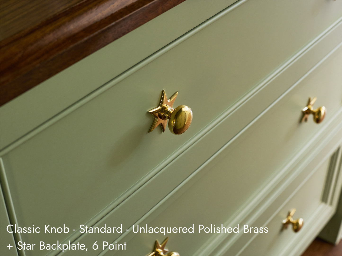 Solid brass Classic Knob, in unlacquered polished brass finish, on kitchen cabinets with Star Backplate.