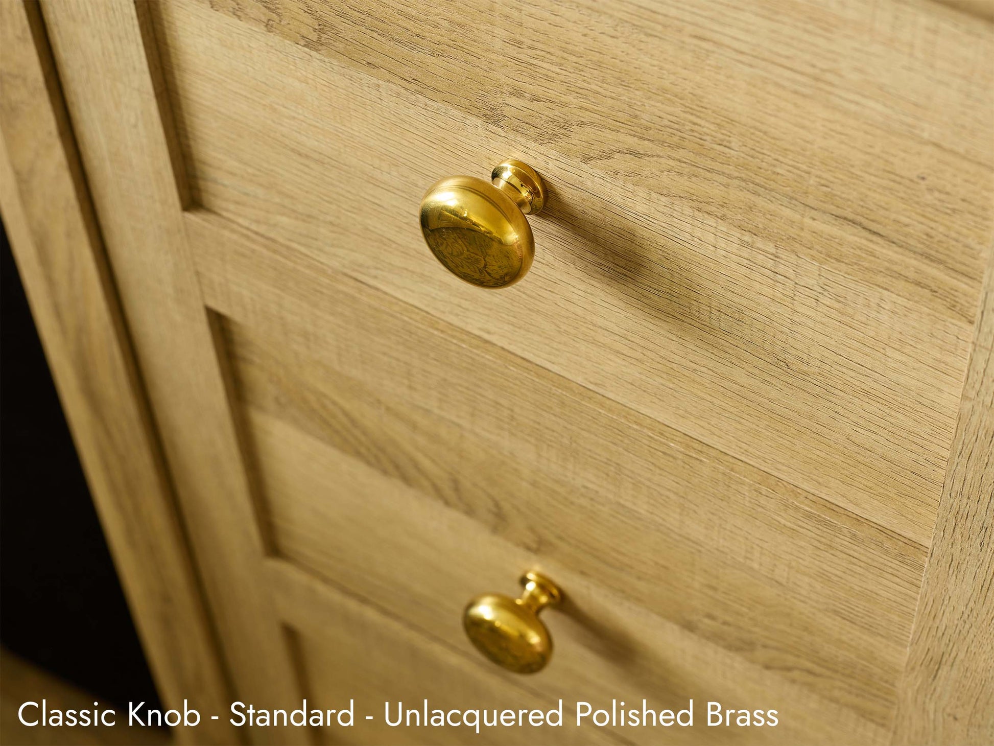 Solid brass Classic Knob, in unlacquered polished brass finish, on kitchen cabinets.