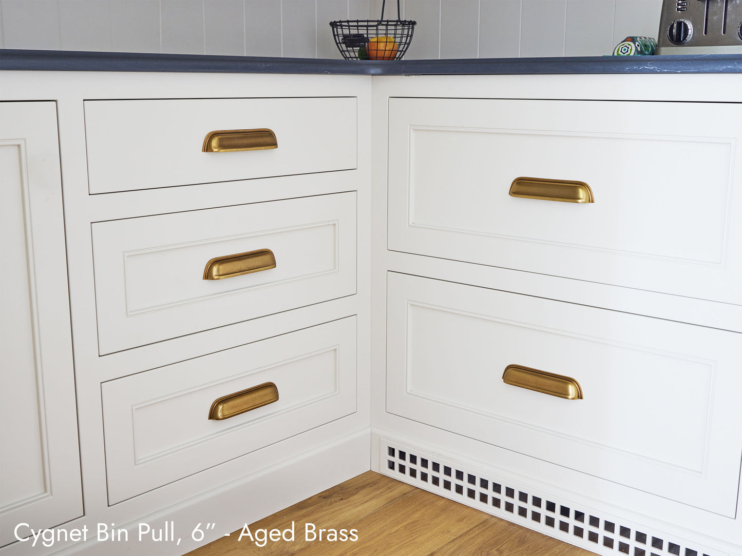 Solid brass Cygnet Bin Pulls, in aged brass finish, on kitchen cabinets.