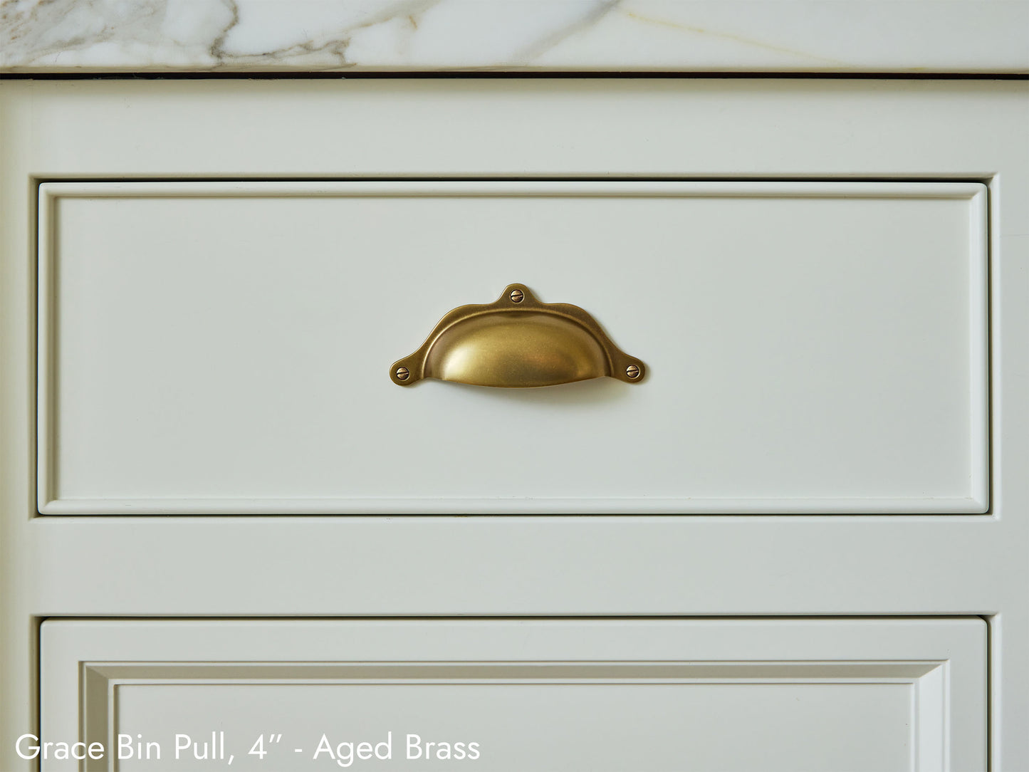 Solid brass Grace Bin Pull, in aged brass, on kitchen cabinets.