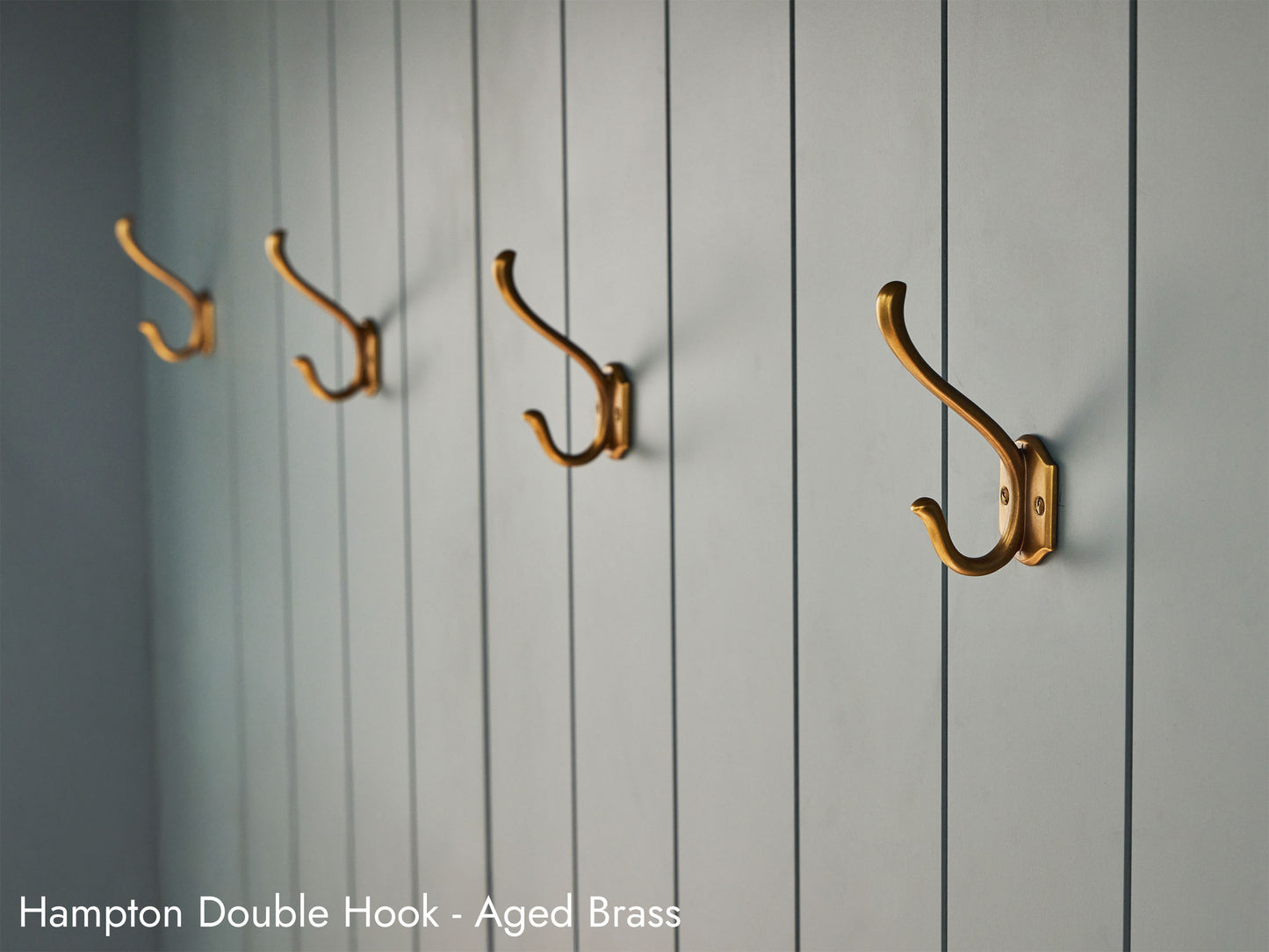 Solid brass Hampton Double Hooks, in aged brass finish, in a mudroom.