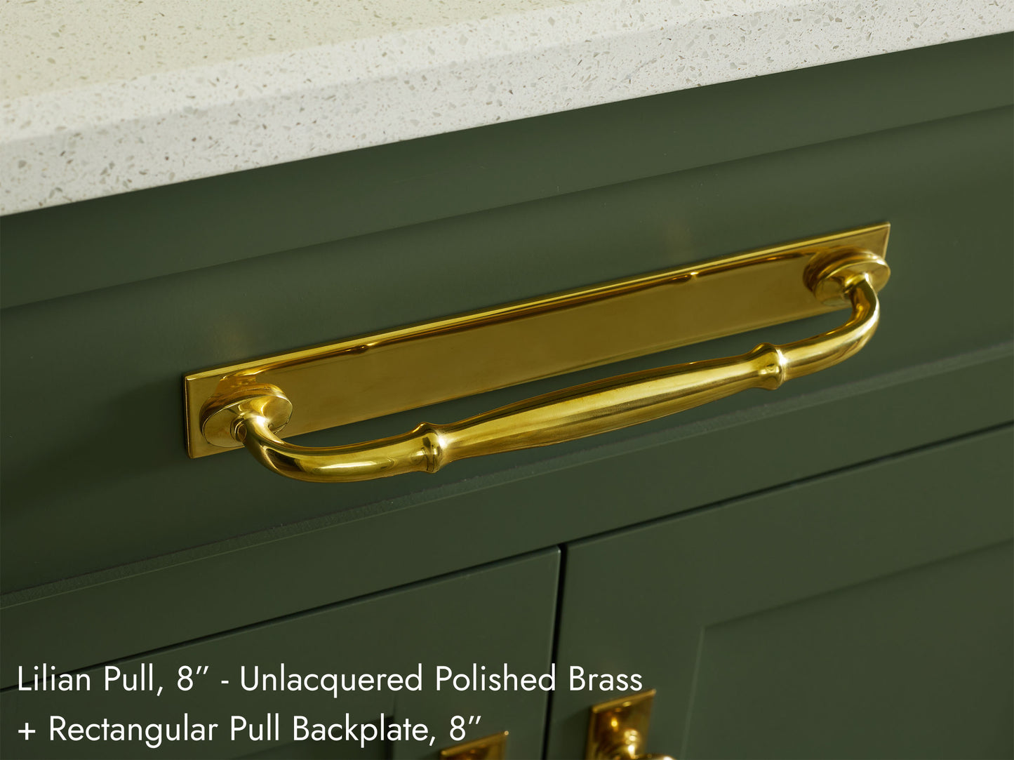 Solid brass Lilian Pull, in a unlacquered polished brass finish, on kitchen cabinets with a Rectangular backplate.