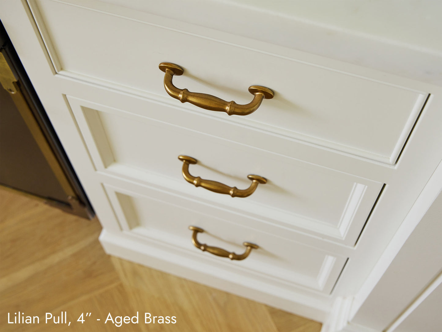 Solid brass Lilian Pulls, in aged brass finish, on kitchen cabinets.