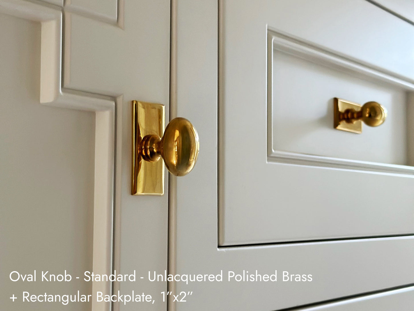 Solid brass Oval Knob, in unlacquered polished brass finish, on kitchen cabinets with a rectangular backplate.