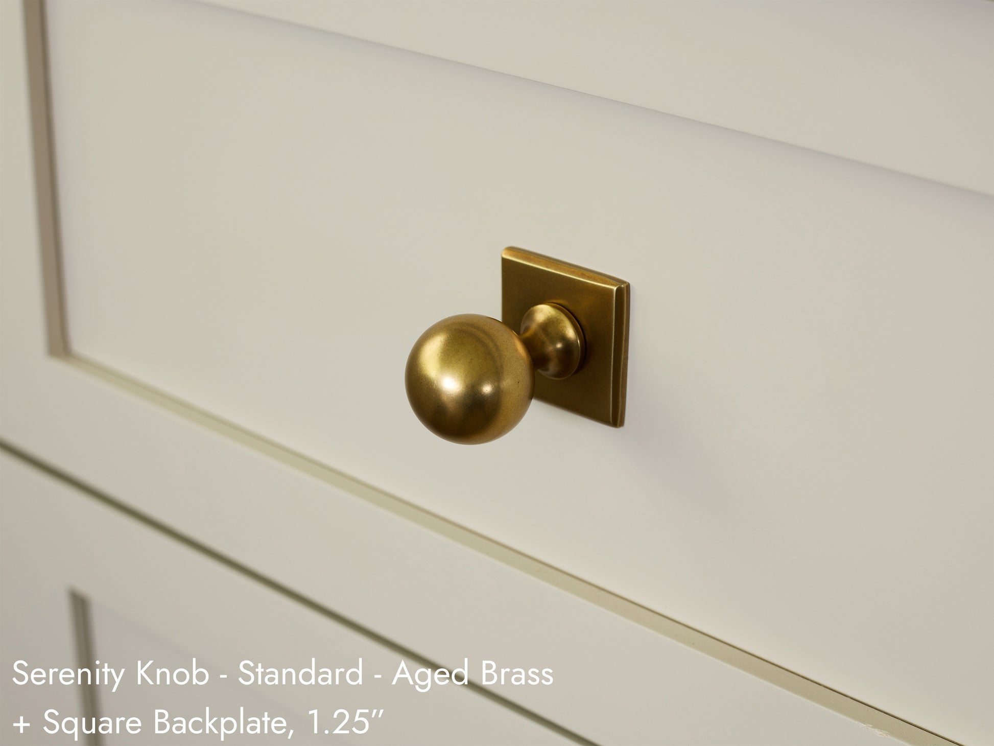 Solid brass Serenity Knob, in aged brass finish, on kitchen cabinets with Square Backplate.