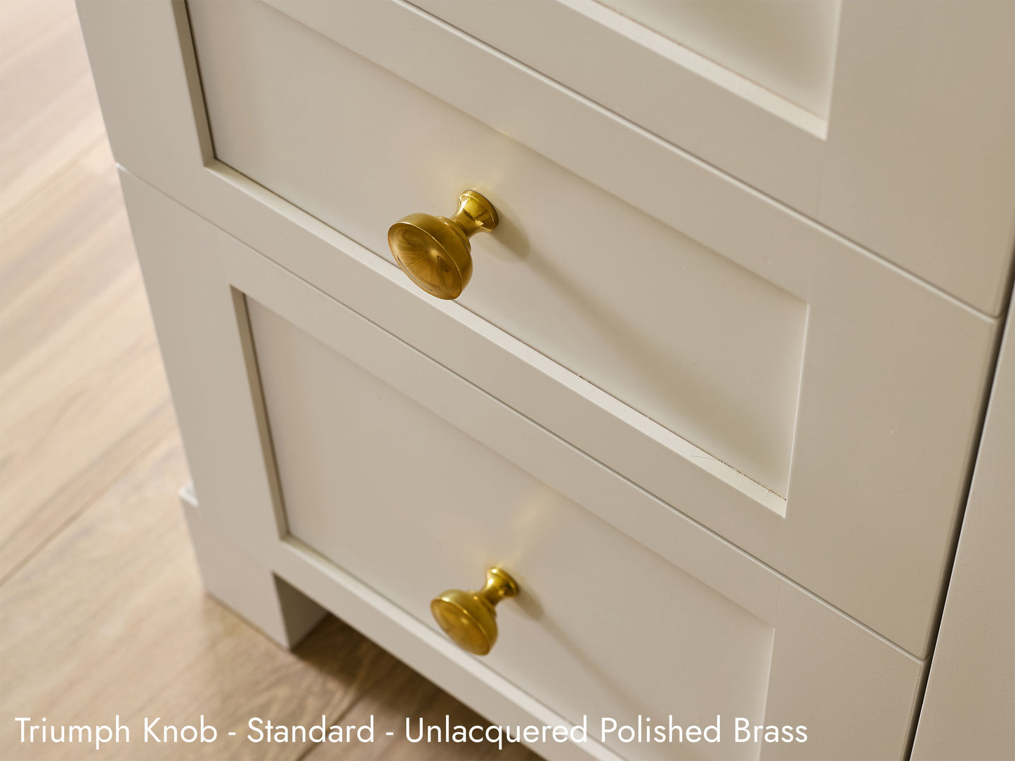 Solid brass Triumph Knob, in unlacquered polished brass finish, on kitchen cabinets.