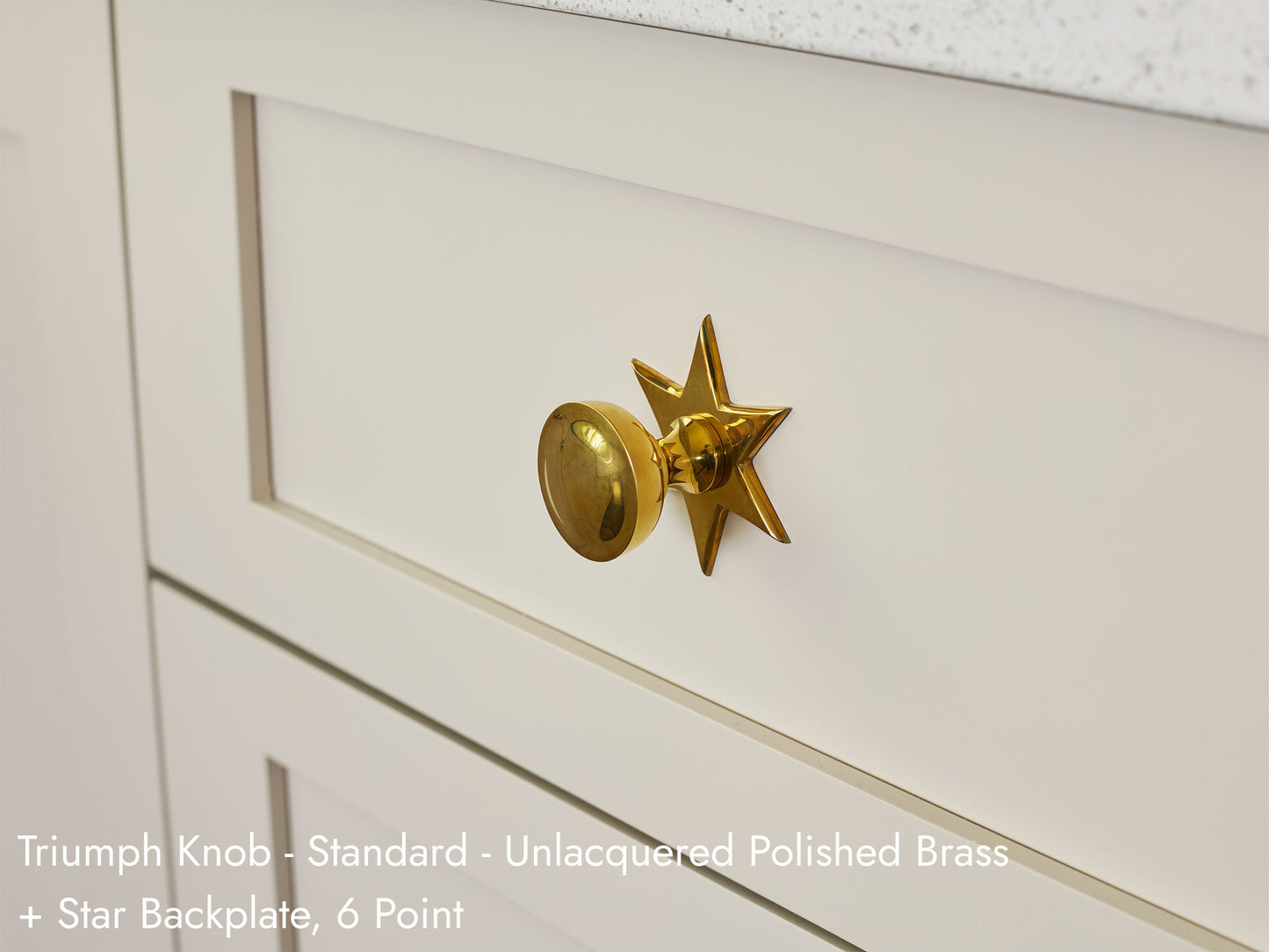 Solid brass Triumph Knob, in unlacquered polished brass finish, on kitchen cabinets with Star Backplate.