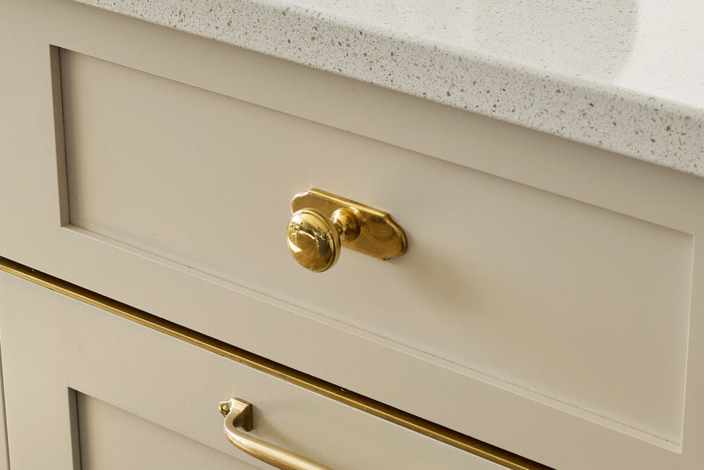 Traditional kitchen with unlacquered brass hardware on its cabinetry.