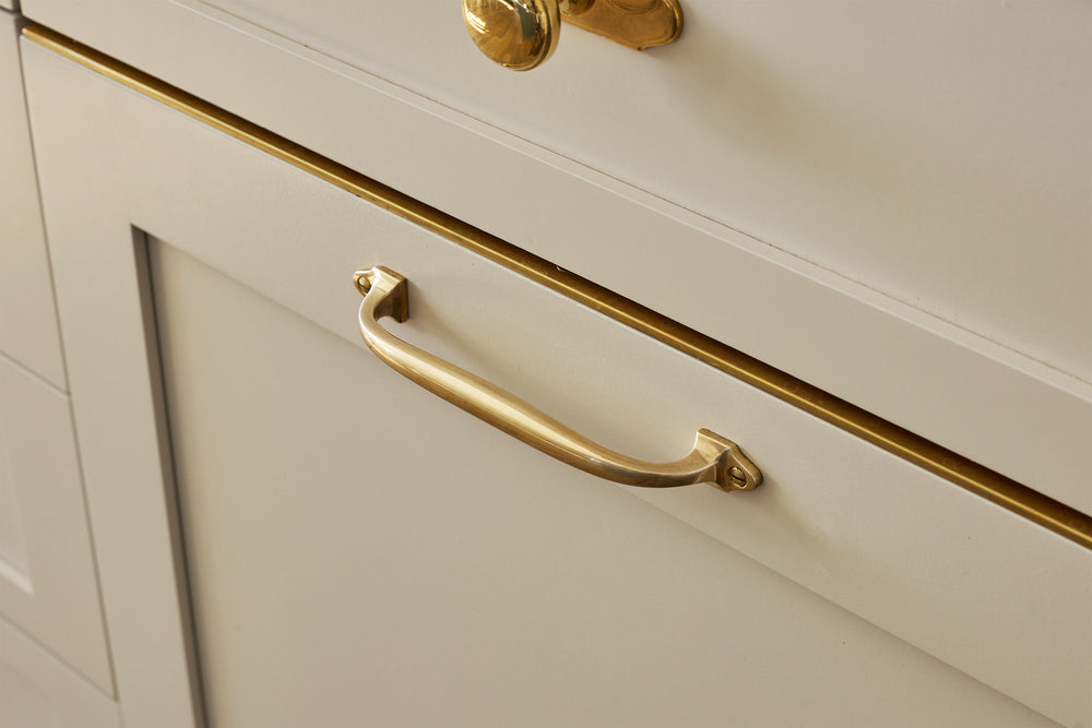 Traditional kitchen with unlacquered brass hardware on its cabinetry.