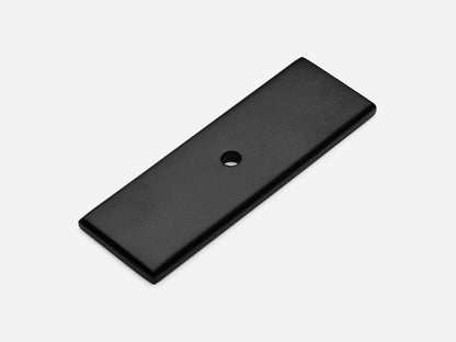 Solid brass rectangular backplate, 1x3 inches, matte black finish for knobs and pulls on cabinets.