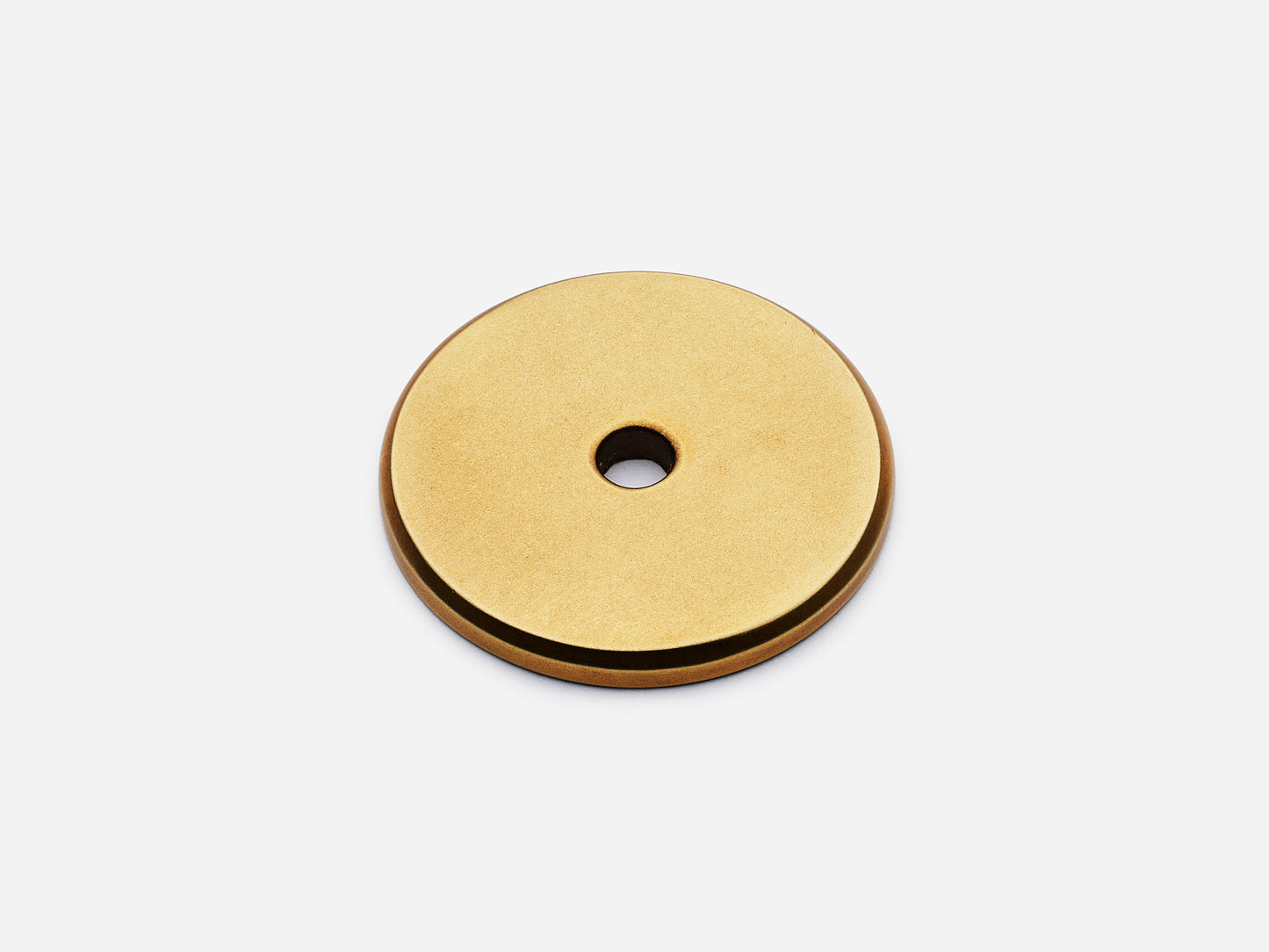Solid brass Round backplate, 1.25 inches, in an aged brass finish for knobs on cabinets.