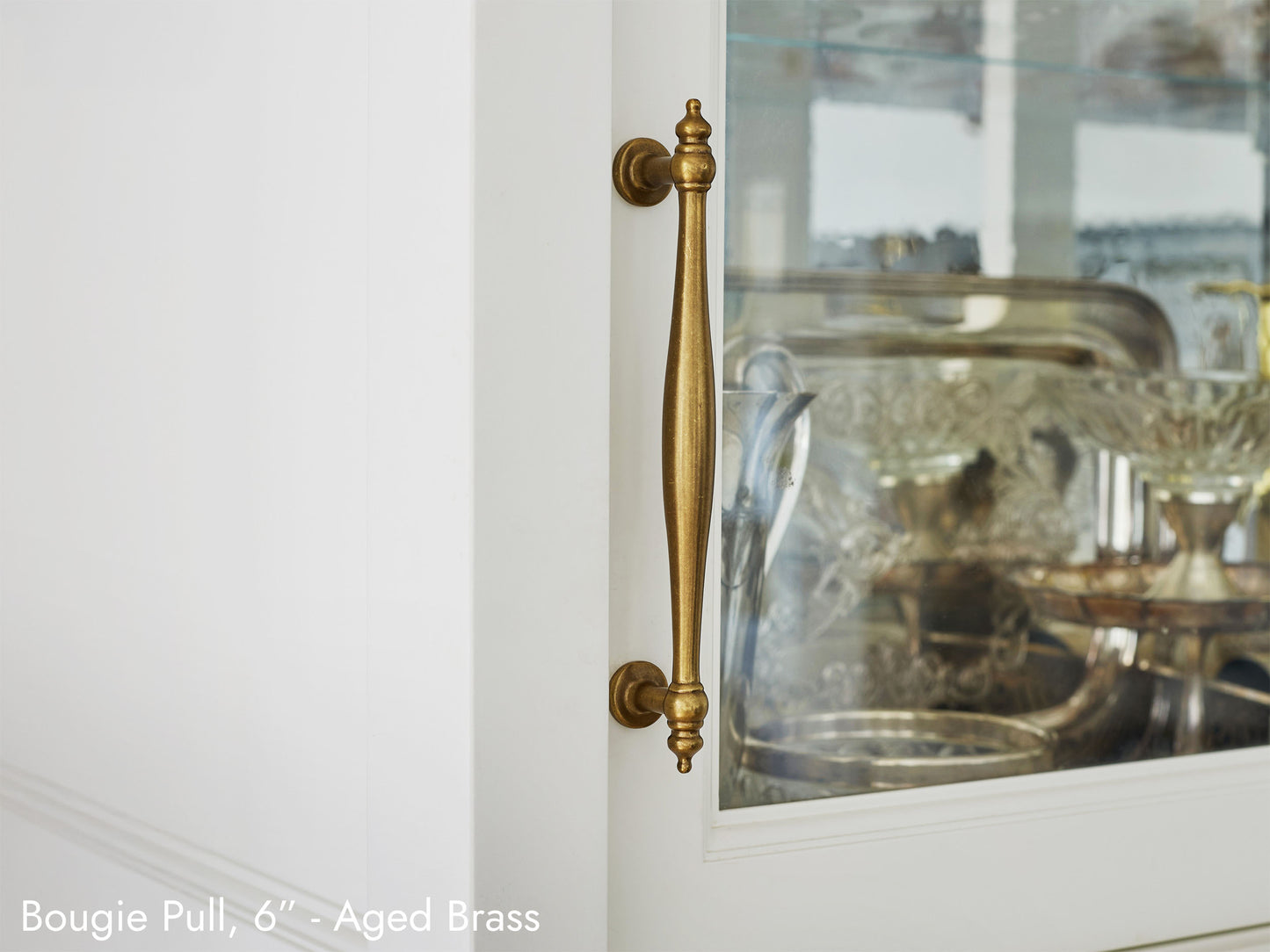 Solid brass Bougie Pull, in aged brass finish, on kitchen cabinets.