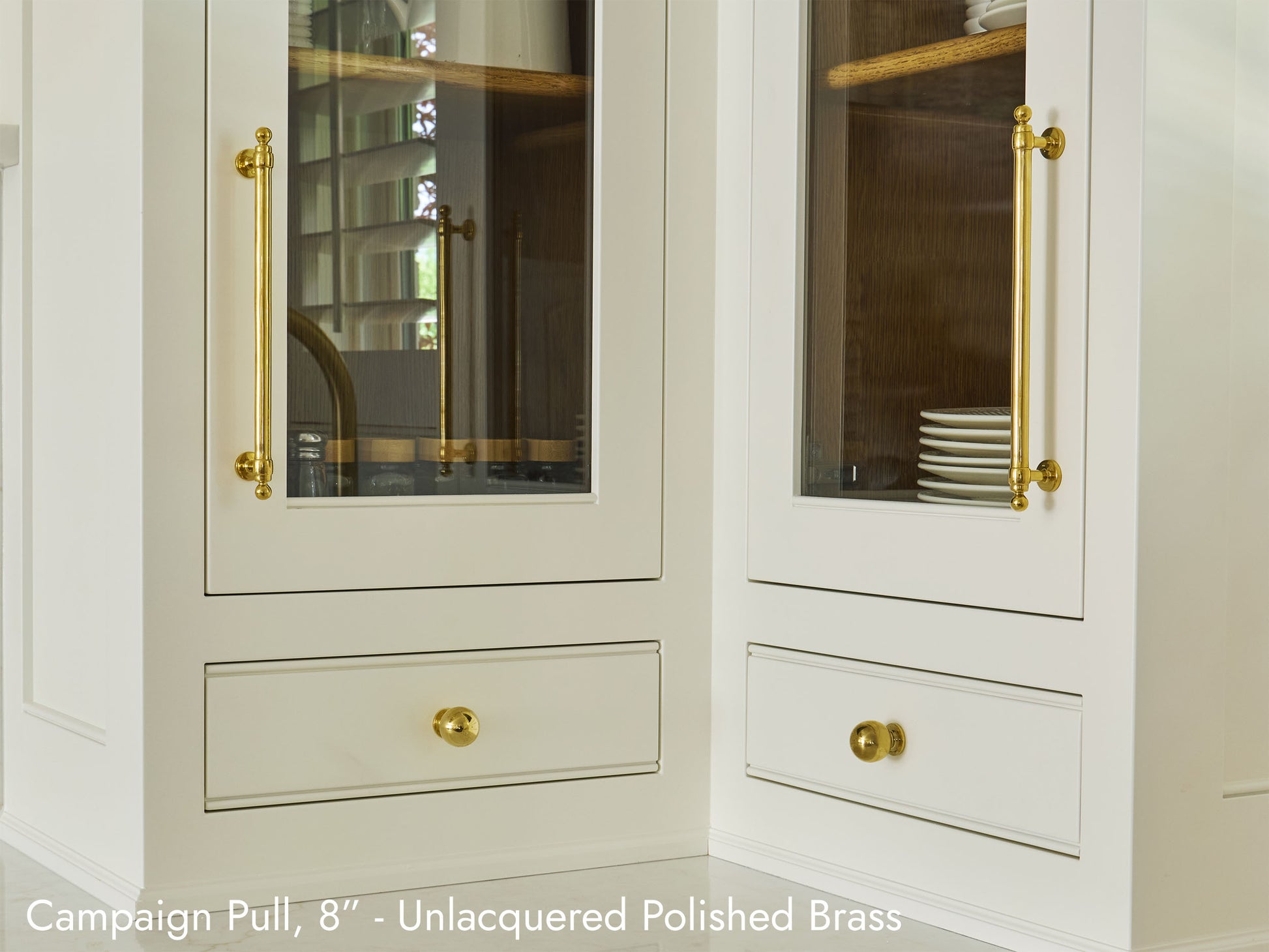 Solid brass Campaign Pull, in unlacquered polished brass finish, on kitchen cabinets.