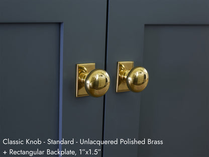 Solid brass Classic Knob, in unlacquered polished brass finish, on kitchen cabinets with Rectangular Backplate.