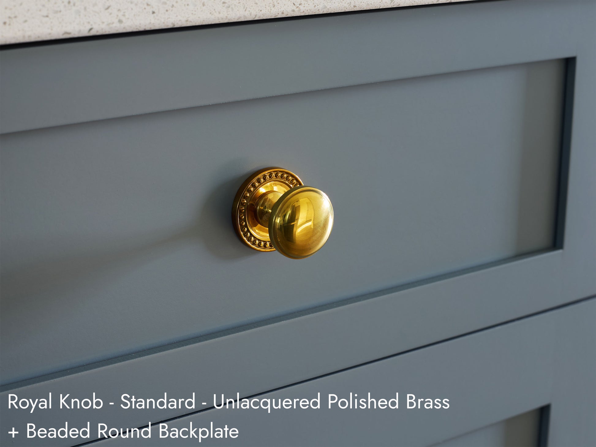 Solid brass Royal Knob, in unlacquered polished brass finish, on kitchen cabinets with Beaded Round Backplate.