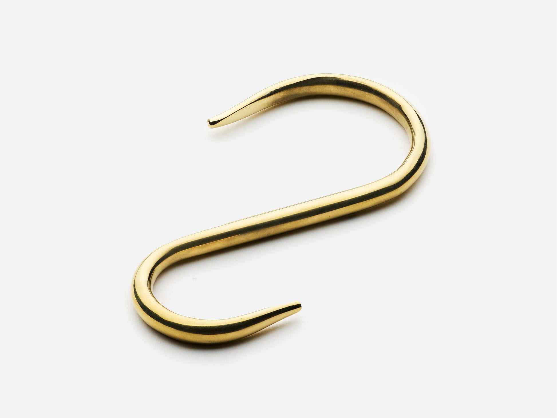 Solid brass S-hook for hanging pot rail in an unlacquered polished brass finish for kitchens.